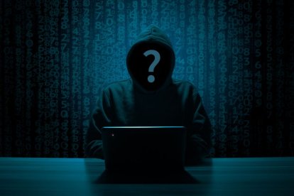 Silueta encapuchada de un hacker recopilando la 