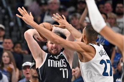 26 de mayo de 2024; Dallas, Texas, EE.UU.; El escolta de los Dallas Mavericks Luka Doncic (77) controla el balón contra el pívot de los Minnesota Timberwolves Rudy Gobert (27) en el segundo cuarto durante el tercer partido de las finales de la conferencia oeste de los playoffs de la NBA 2024 en el American Airlines Center.