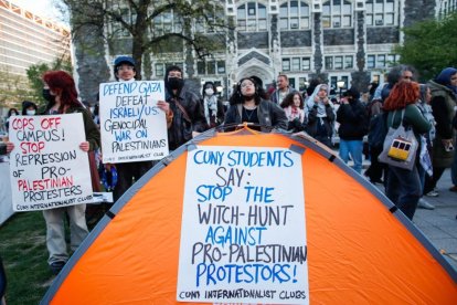 La gente sostiene pancartas mientras manifestantes pro palestinos se reúnen en el campus del City College de Nueva York