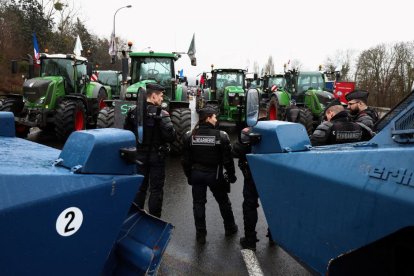 Gendarmes franceses y sus blindados controlan un grupo ed agricultores con tractores