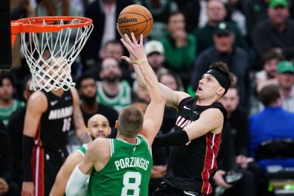 24 de abril de 2024; Boston, Massachusetts, EE.UU.; El escolta de los Miami Heat Tyler Herro (14) conduce hacia la canasta contra el pívot de los Boston Celtics Kristaps Porzingis (8) en la segunda mitad durante el segundo partido de la primera ronda de los playoffs de la NBA 2024 en el TD Garden.