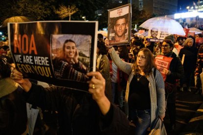 Mujeres israelíes marchan mientras sostienen carteles con las fotos de los rehenes israelíes Noa Argamani y Oz Daniel durante una manifestación en Tel Aviv en demanda de un acuerdo inmediato sobre los rehenes y un alto el fuego.