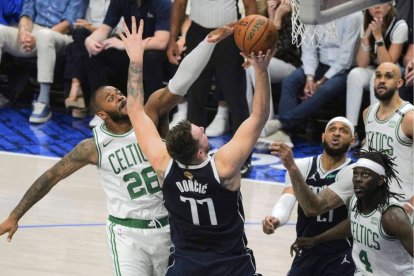 Doncic lanza a canasta ante la oposición de jugadores de Boston.