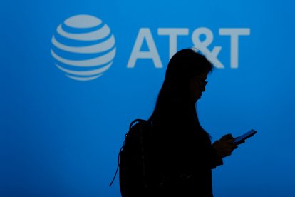 Un visitante pasa junto al logotipo de la multinacional estadounidense de telecomunicaciones AT&T durante el Mobile World Congress (MWC), el mayor encuentro anual de la industria de las telecomunicaciones, en Barcelona el 26 de febrero de 2024.