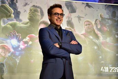 Robert Downey Jr. posa frente a un cartel publicitario de Los Vengadores.