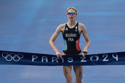 31 July 2024, France, Paris: Olympic Games, Paris 2024, triathlon, Olympic distance (1.5 km swim, 40 km bike, 10 km run), Cassandre Beaugrand from France crosses the finish line as the winner. Photo: Jan Woitas/dpa