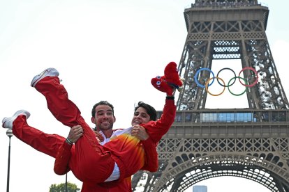 El marchador español Álvaro Martín coge en brazos a María Pérez para celebrar el oro en el maratón por relevos mixtos de marcha en el podio.