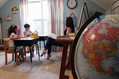 Image #: 34087258    Homeschooled siblings Elena Forte, 7, left, and Devon Forte, 8, center, color pictures of famous figures in history while homeschooling mom Andrea Forte, reads to them about the history of the colorful European kings and queens of the Middle Ages during the kids' language arts and history class time upstairs in the Forte family home on Aug. 11, 2014 in Wake Forest, N.C. Forte teaches her kids about four hours a day, five days a week. (Harry Lynch/News & Observer/TNS)       Raleigh News & Observer/ TNS /LANDOV