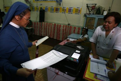 Una monja deposita su voto en un colegio electoral en Manila, Filipinas, el 13 de mayo de 2013.