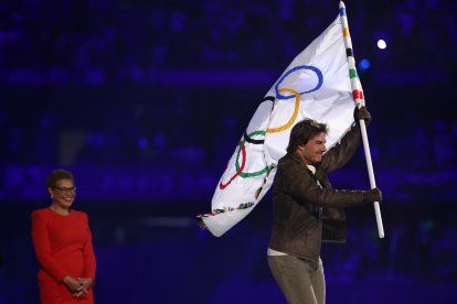 El actor estadounidense Tom Cruise sale con la bandera olímpica ante la alcaldesa de Los Ángeles, Karen Bass