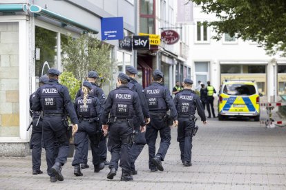 25 August 2024, North Rhine-Westphalia, Solingen: Police officers walk past the scene at midday. Three people were killed and several injured in an attack at the 650th anniversary celebrations of the city of Solingen on 23.08.2024. Photo: Thomas Banneyer/dpa