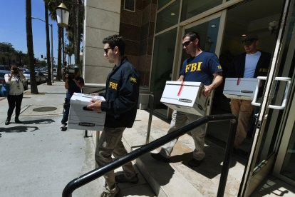 Agentes del FBI retiran cajas de documentos de las oficinas del California Investment Immigration Fund tras presentar órdenes de registro en el marco de una investigación sobre una presunta trama de fraude de visados de alta gama por valor de 50 millones de dólares en la que están implicados hasta 100 ciudadanos chinos en San Gabriel, California, el 5 de abril de 2017.