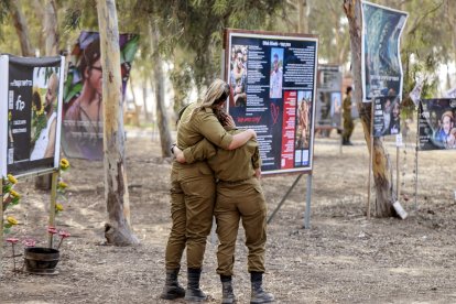 Guerra en Israel: Soldadas del ejército israelí se abrazan mientras visitan un monumento en memoria de las víctimas asesinadas o secuestradas en el festival de música Supernova