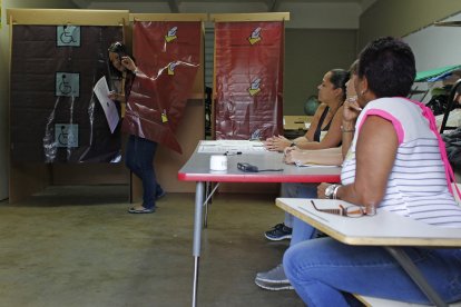 Una mujer sale de una cabina de votación después de emitir su voto durante el referéndum para el estatus político de Puerto Rico en un colegio electoral en Guaynabo, el 11 de junio de 2017.