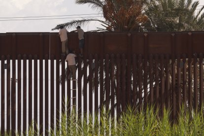 Crisis fronteriza: Migrantes utilizan una escalera de cuerda para saltar ilegalmente el muro fronterizo que separa Estados Unidos de México el 6 de octubre de 2022 en El Centro, California.