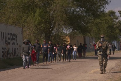 Un oficial de la Guardia Nacional de Texas guia a un grupo de inmigrantes hacia la Patrulla Fronteriza de Estados Unidos