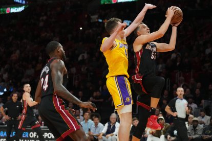 El alero de los Miami Heat Duncan Robinson (55) conduce hacia la canasta mientras el escolta de Los Angeles Lakers Dalton Knecht (4) defiende en la primera mitad en el Kaseya Center.