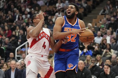 El pívot de los New York Knicks Karl-Anthony Towns (32) conduce contra el alero de los Toronto Raptors Scottie Barnes (4) durante la primera mitad en el Scotiabank Arena.