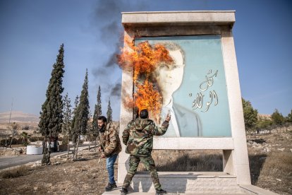 : Un hombre quema una foto del ex presidente sirio Bashar Asad cerca de la frontera de Siria con Líbano