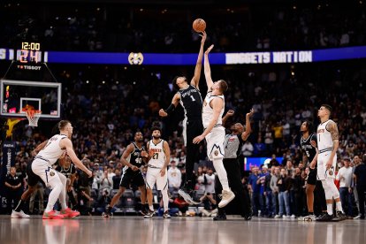 El pívot de los San Antonio Spurs Victor Wembanyama (1) y el pívot de los Denver Nuggets Nikola Jokic (15) saltan a por el balón para comenzar el partido en el Ball Arena.