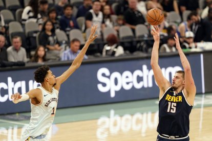 El pívot de los Denver Nuggets Nikola Jokic (15) lanza el balón por encima del pívot de los San Antonio Spurs Victor Wembanyama