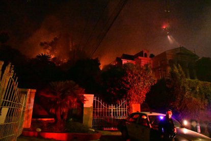 Un agente de policía bajo la maleza en llamas en el incendio de Sunset, cerca de Hollywood Blvd, en Hollywood Hills, Los Ángeles, California, el 8 de enero de 2025.