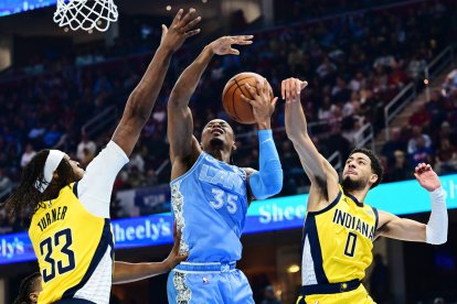 El escolta de los Indiana Pacers Tyrese Haliburton (0) bloquea el tiro del alero de los Cleveland Cavaliers Isaac Okoro (35) mientras el pívot Myles Turner (33) también defiende durante la primera mitad en el Rocket Mortgage FieldHouse.