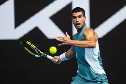 Carlos Alcaraz da un revés de raqueta durante su partido contra Yoshihito Nishioka durante el Open de Australia