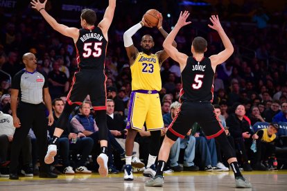 El alero de los Miami Heat Duncan Robinson (55) y el alero Nikola Jovic (5) defienden ante el alero de Los Ángeles Lakers LeBron James (23) durante la segunda parte en el Crypto.com Arena.