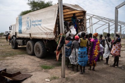 Mujeres descargan sacos de un camión del Programa Mundial de Alimentos (PMA)