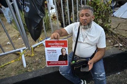 A man holds a photo of a missing relative at the Jet Set nightclub after the roof collapsed in Santo Domingo.