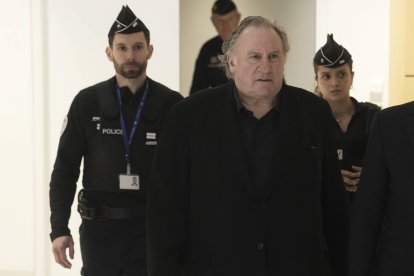Gérard Depardieu, escorted by several police officers