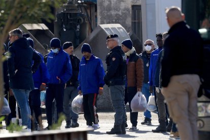 Migrants intercepted in Italian waters disembark after arriving in the Albanian port of Shengjin.