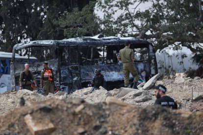 Miembros de los servicios de seguridad y emergencia israelíes se despliegan en el lugar del impacto de un misil iraní