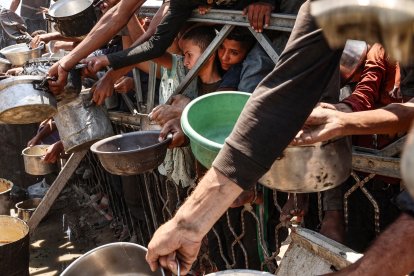 Palestinos se agolpan en un punto de distribución de sopa de lentejas en la ciudad de Gaza