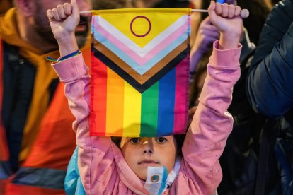 Una menor sostiene una bandera trans (Archivo)
