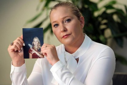 Virginia Giuffre, víctima de Epstein, sosteniendo una foto suya de adolescente