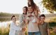 Familia formada por padre, madre y tres hijos, uno de ellos en hombros de su padre