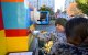 Un niño toca un tranvía de tamaño natural construido con ladrillos clásicos de Lego en la plaza Deak Ferenc, en el centro de Budapest, el 21 de noviembre de 2024. - El tranvía fue diseñado por el artista visual de Budapest Balazs Doczy. El vehículo mide 11,5 metros de largo, dos de alto y dos de ancho. Se construyó con casi 1,8 millones de ladrillos y se dice que es el primero de su clase en el mundo.