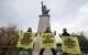 France's Greenpeace activists perform an action to support Greenpeace USA, next to Statue of Liberty at Pont de Grenelle in Paris on February 20, 2025. Energy Transfer, the Big Oil company behind the Dakota Access Pipeline, is suing Greenpeace USA for $300 million. (Photo by Thibaud MORITZ / AFP)