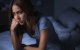 Una mujer sentada al borde de la cama sin lograr conciliar el sueño