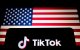 El logotipo de TikTok se muestra en un smartphone junto a la bandera de Estados Unidos. TikTok es una aplicación lanzada en 2016 por ByteDance, una empresa tecnológica china.