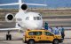 Pasajeros con trajes protectores azules abordan un avión tras ser evacuados del crucero MV Hondius