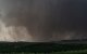 Un violento tornado en forma de cuña, envuelto en lluvia, arrasa tierras de cultivo (Archivo)