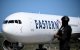 Un avión estadounidense carretea en el aeropuerto Simón Bolívar de Maiquetía. En primer plano, un funcionario de la Policía Nacional Bolivariana.