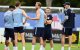 El delantero inglés n.º 9, Harry Kane (C), habla con sus compañeros de equipo mientras el seleccionador alemán de Inglaterra, Thomas Tuchel (D), observa la escena durante una sesión de entrenamiento en el marco de la preparación del equipo para su primer partido del Mundial de fútbol contra Croacia, en la concentración del equipo en Palm Beach Gardens, el 9 de junio de 2026.