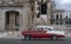 Un coche viejo pasa junto a los escombros de una casa en La Habana (Archivo)