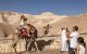 Tourists pose for a picture while riding camels near the sign marking mean sea level (Files)