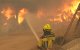 Un bombero rocía con agua neumáticos y barriles en llamas cerca de Ávila, España