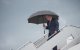 El presidente Donald Trump camina bajo un paraguas al desembarcar del Air Force One en la Base Conjunta Andrews, Maryland, el 2 de agosto de 2026.